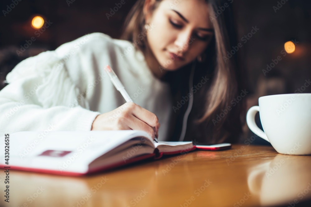 Pensive woman student writing notes while studying Pensive woman student writing notes while studying