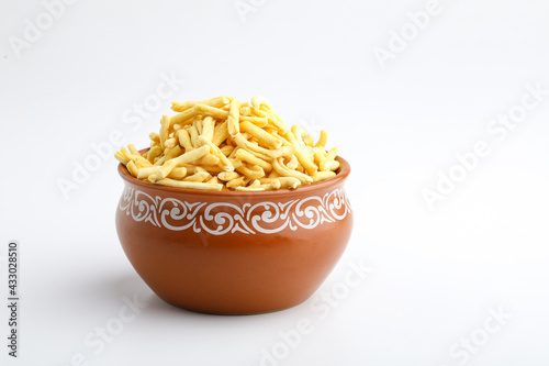 Bhavnagari Gathiya is a very popular Gujarati snack, brown bowl on white background photo