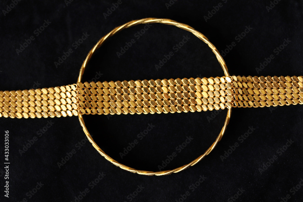 gold bracelets on a black background