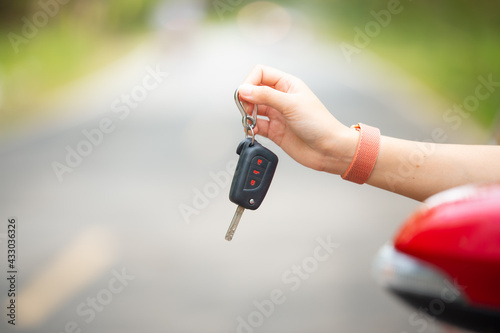 Close up of hand woman driver showing car keys on car door
