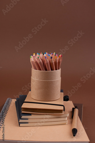 branding mockup with many craft paper and different subjects. Office desk with a paper notepad and a box of pencils. Contemporary workspace for men, minimalist style. Mockup. Copy space photo