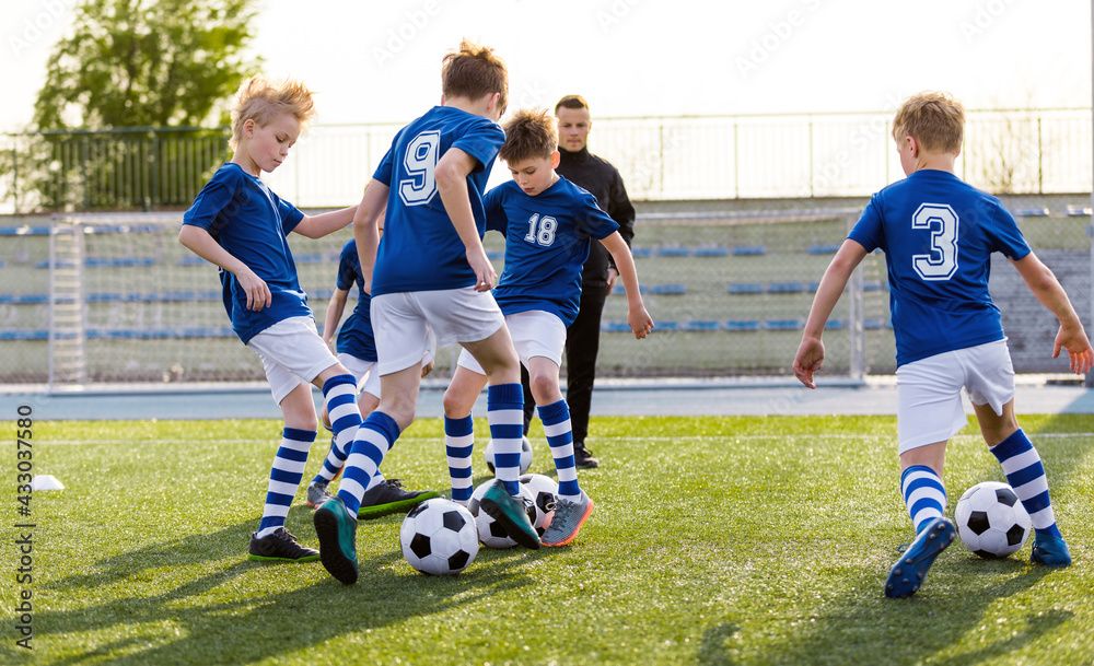 Youth Football Club Training Unit. Kids Practicing Football With Young Coach. Group of Kids