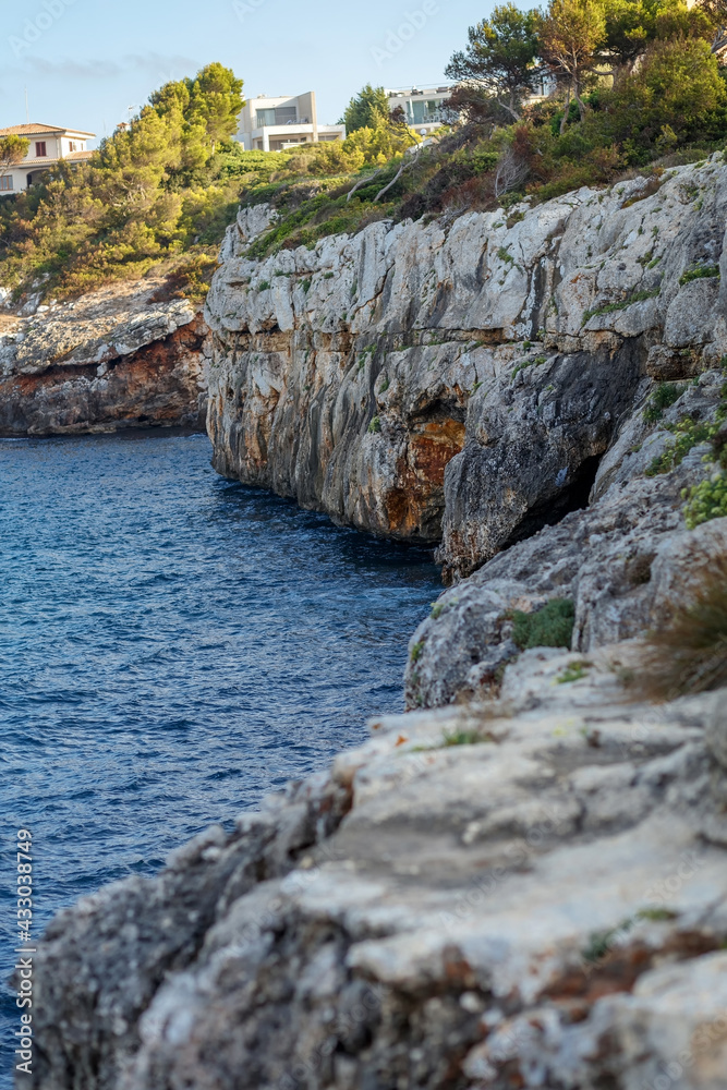 Rocky seashore. Steep coast. A steep cliff near the sea. Porto Cristo, Mallorca. Travel Concept. High quality photo