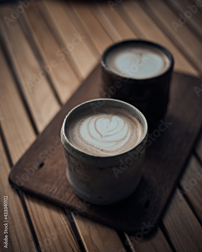 cup of hot latte art coffee on wooden