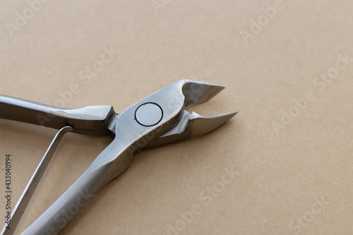 Metal steel nippers or pliers for professional manicure and pedicure. Macro shot of tools for pedicure and manicure on a beige background. Nail care concept