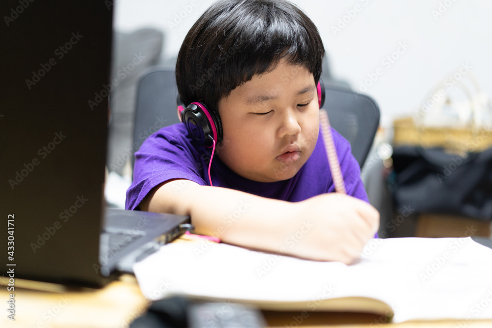 A boy stays home and studying online. A boy stays home and studying online.