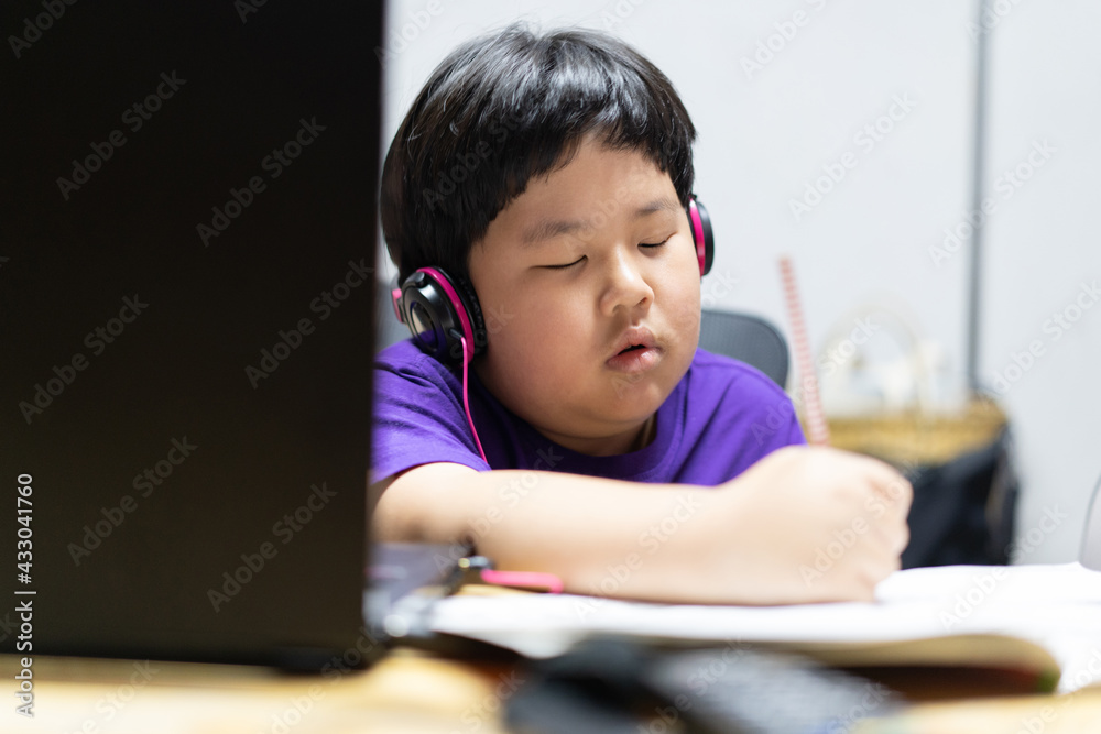 A boy stays home and studying online. A boy stays home and studying online.
