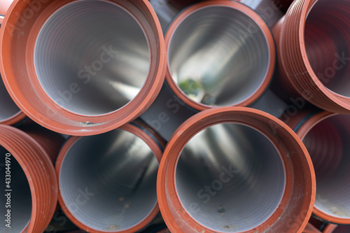 Stacked orange sewage pipes, sunset 