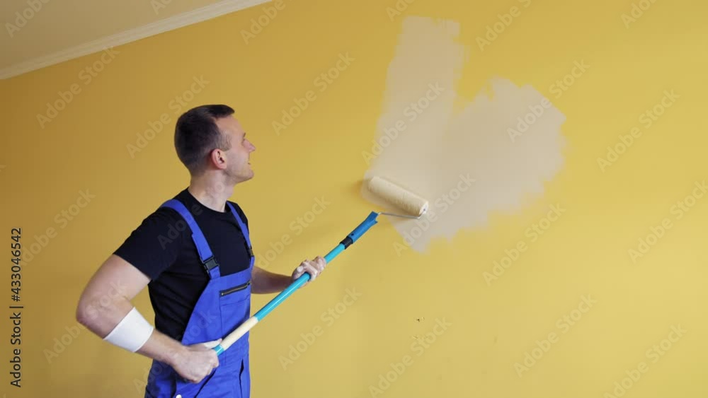 Handsome male painter doing room improvement. Attractive man improve house interior. Handsome male painter doing room improvement. Attractive man improve house interior.