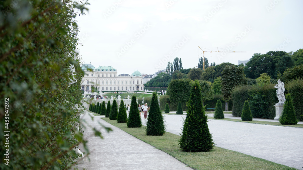 Schloss Belverdere in Wien mit Schlossgarten im Sommer, blühenden Blumen und wolkigem Himmel