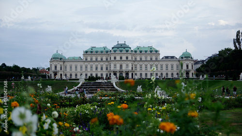 Schloss Belverdere in Wien mit Schlossgarten im Sommer, blühenden Blumen und wolkigem Himmel