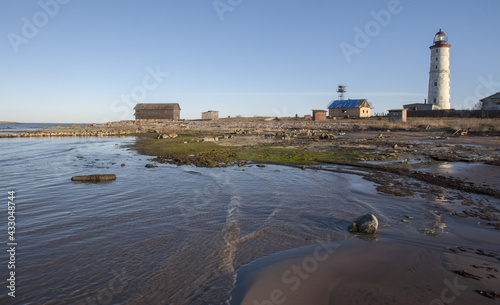 Peaceful sea shoreline with the Vilsandi Lighthouse in the background photo