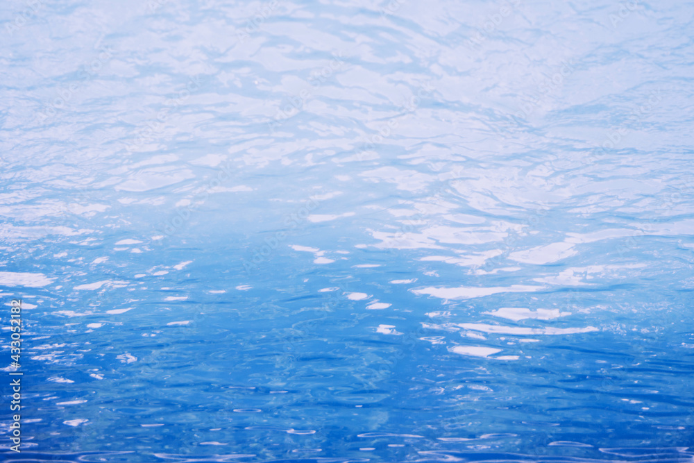 Surface of blue swimming pool. Under water. Background of blue ripped water in swimming pool