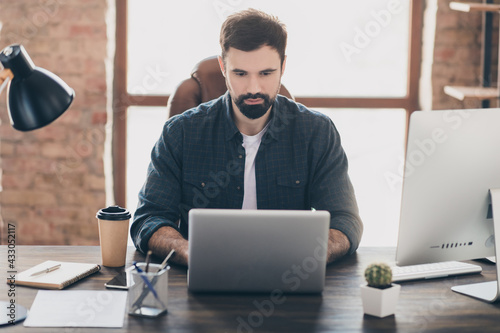 Photo portrait of bearded worker using laptop browsing internet working on quarantine photo