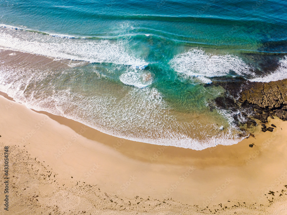 Obraz premium Aerial view of a beach and rolling waves