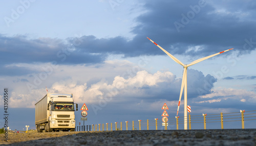 Truck driving on the highway, wind turbines near the road