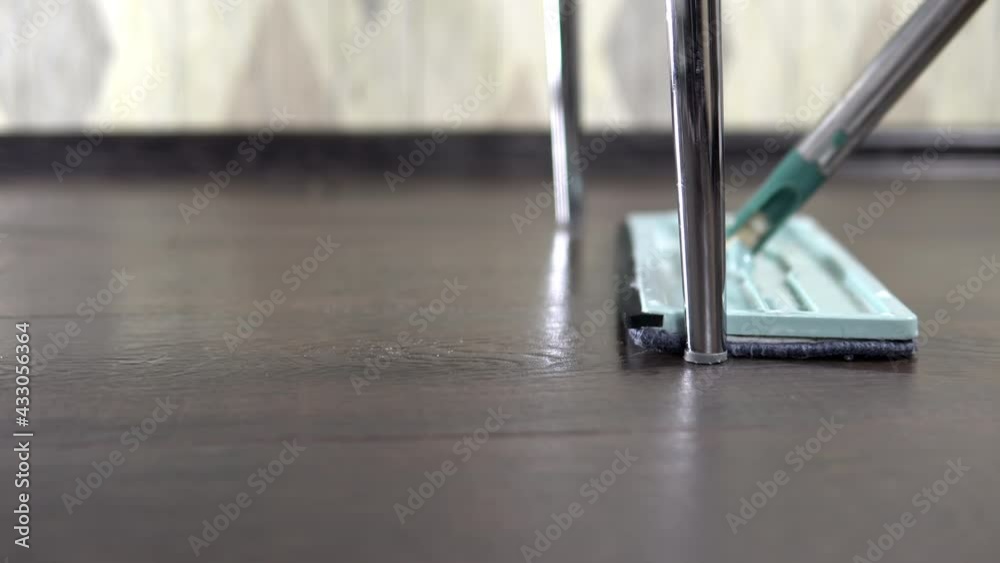 Shooting in close-up, the hostess wipes the floor near the leg under the chair Shooting in close-up, the hostess wipes the floor near the leg under the chair