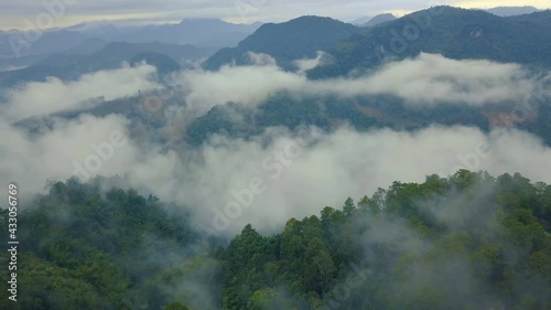 Aerial View. Flying over the high mountains forest with village in beautiful clouds fog, at Doi luang Chiang dao, Chiang mai, Thailand.
