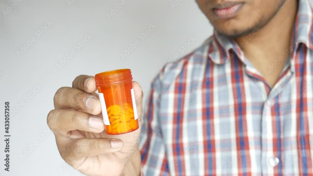 person hand holding pill container person hand holding pill container
