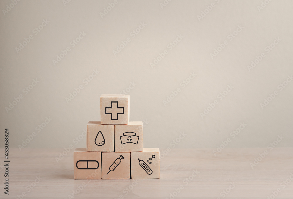 Fototapeta premium Health and life insurance concept for emergency medical treatment, with medical icons on wooden blocks.
