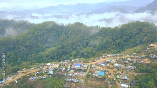 Aerial View. Flying over the high mountains forest with village in beautiful clouds fog, at Doi luang Chiang dao, Chiang mai, Thailand.