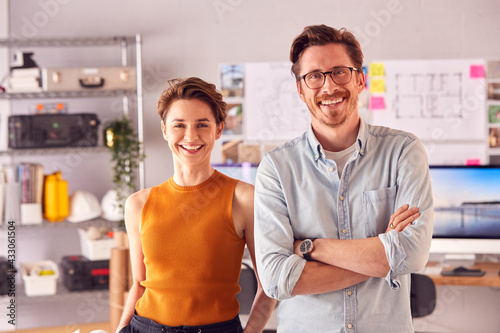 Portrait Of Male And Female Architects In Office Standing By Desks