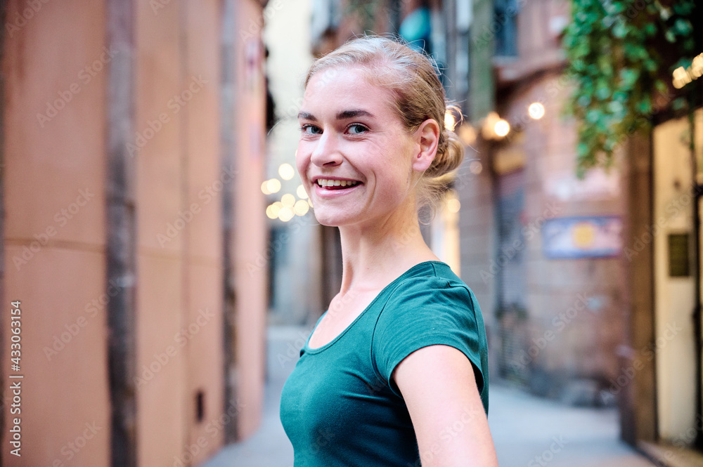 Fototapeta premium portrait of a young beautiful woman looking at camera outdoors with natural light