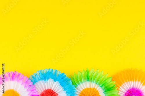 Decoration of bright striped umbrellas on a yellow background