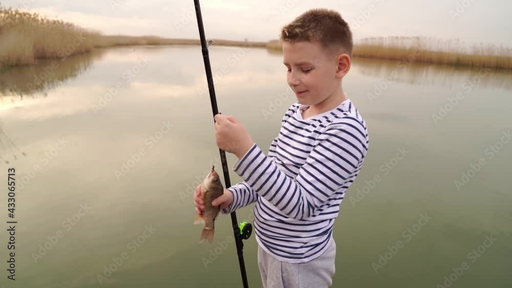 boys caughts a small fish on a fishing rod. fishing with children. boys caughts a small fish on a fishing rod. fishing with children.