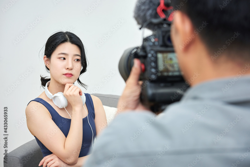 Asia Korean woman professional vlogger or blogger live broadcasting on social media with cameraman Asia Korean woman professional vlogger or blogger live broadcasting on social media with cameraman