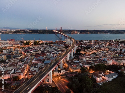 Obraz na płótnie Aerial view of April 25th bridge with Christ the King statue (Cristo Rei) in background at sunset, view of Lisbon skyline at night, Alcântara, Lisbon, Portugal. w salonie