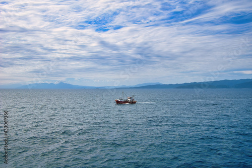 small fishing boat in troubled sea photo