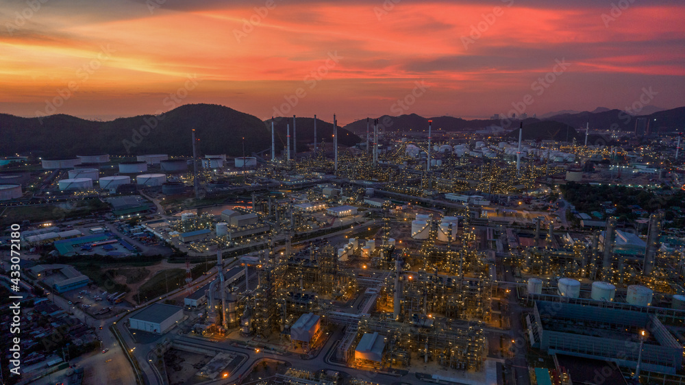 Chemical oil refinery plant, power plant and metal pipe on sunset sky background.