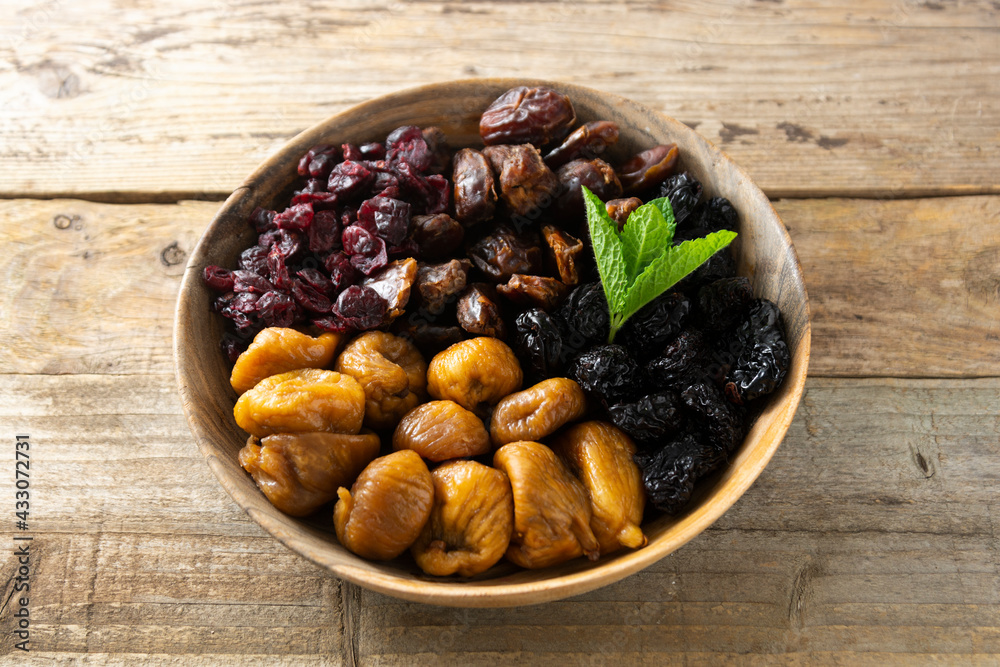 Dried fruits on wooden plate, healthy snack, sweet fruits, rustic style Dried fruits on wooden plate, healthy snack, sweet fruits, rustic style