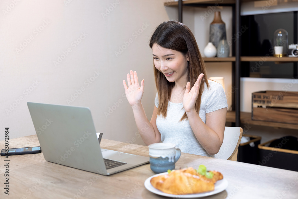 Happy beautiful Asian woman working on a laptop at home, Online video meetings with colleagues. Happy beautiful Asian woman working on a laptop at home, Online video meetings with colleagues.