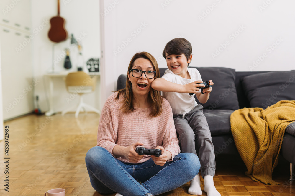 mother and child playing video games at home mother and child playing video games at home