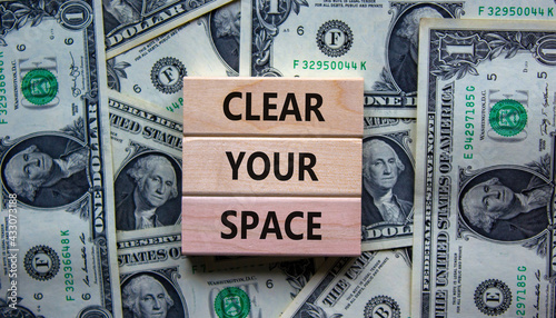 Clear your space symbol. Wooden blocks with words 'Clear your space'. Beautiful background from dollar bills. Business, clear your space concept, copy space.