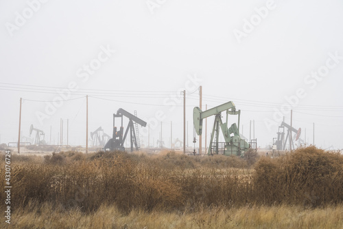 Oil well pump jacks pumping crude oil for fossil fuel energy