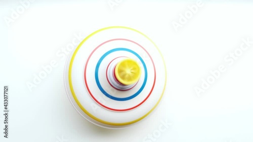 Untwisted whirligig, children toy spinning top spinning on white background.View from top.