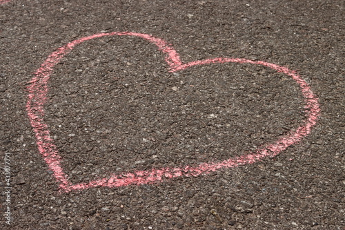 heart in chalk on the asphalt, children's drawing on the sidewalk