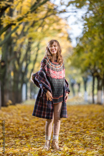 ortrait of beautiful woman wearing sweater in autumn yellow park 