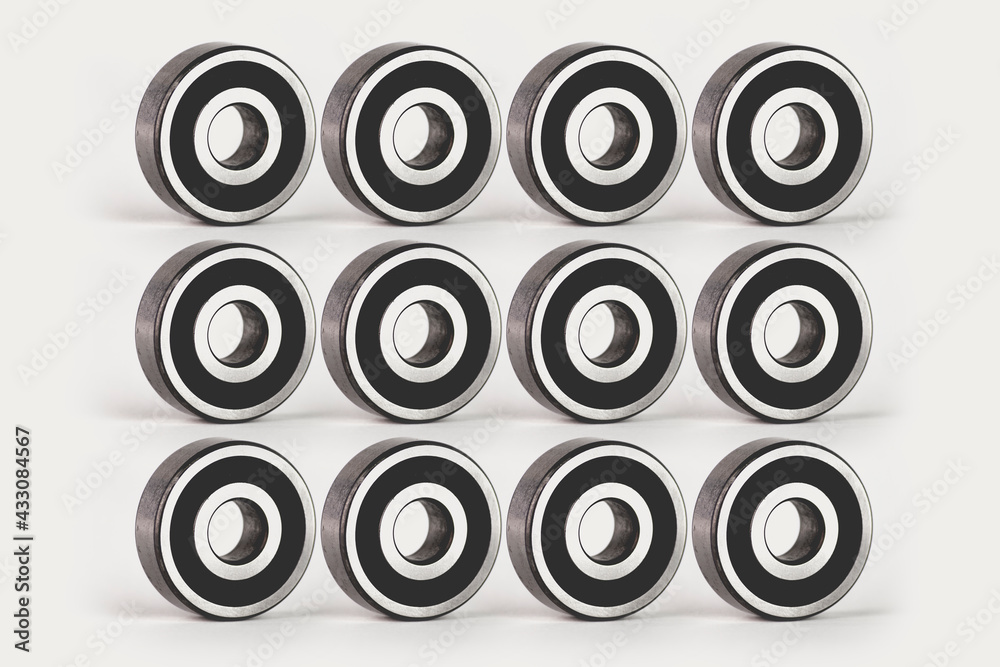 Texture and repetitive pattern of bearings, image created by photo composition, with photographs of bearings on a white background. All the pieces are identical, looking in the same direction. Texture and repetitive pattern of bearings, image created by photo composition, with photographs of bearings on a white background. All the pieces are identical, looking in the same direction.