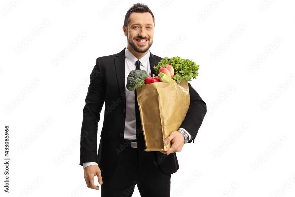 Businessman with a grocery bag smiling at camera Businessman with a grocery bag smiling at camera