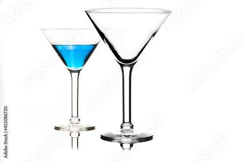 Martini glasses isolated on white with blue drink in one glass