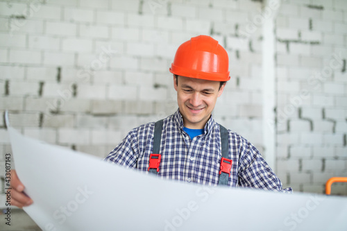 Engineer and Architect working at Construction Site with blue print working and looking blueprint in new house construction site.