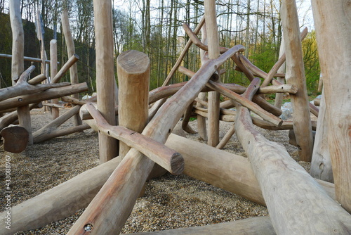 Climbing frame made of tree trunks on a playground with gravel stones in the forest