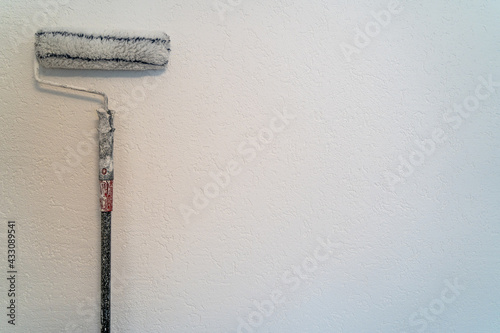 Paint roller on white wall