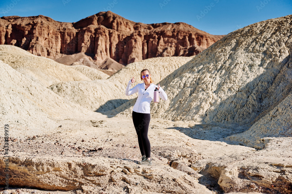 A family hike from Zabriskie Point in Death Valley national park in california. Huge sand dunes, terracotta mountains and hazy horizons are shining against clear blue sky in the midday sun. A family hike from Zabriskie Point in Death Valley national park in california. Huge sand dunes, terracotta mountains and hazy horizons are shining against clear blue sky in the midday sun.