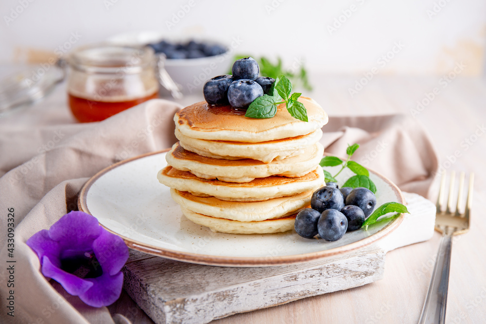 Homemade pancakes with blueberries and powdered sugar on the white table Homemade pancakes with blueberries and powdered sugar on the white table