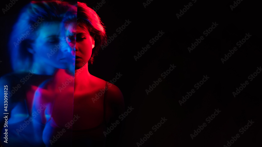 Bipolar disorder. Emotional crisis. Depression loneliness. Blur double exposure silhouette of disturbed upset woman in pink blue neon light isolated on black copy space background.